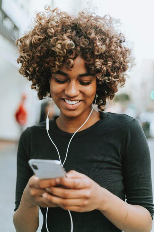 Girl listening to phone through headphones.